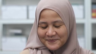 Mutlu kendinden emin Asyalı Müslüman kadın kameraya gülümsüyor, başarılı girişimci, yakın plan portresi