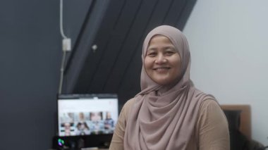 Mutlu kendinden emin Asyalı Müslüman kadın kameraya gülümsüyor, başarılı girişimci, yakın plan portresi