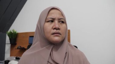 Asyalı Müslüman kadın sinirli yüz ifadesi sergiliyor. Mutsuz jest, yakın plan portre