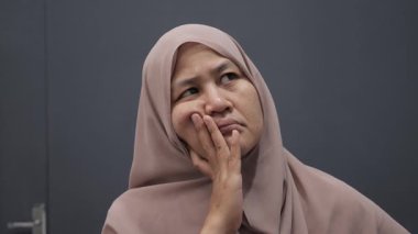 Asyalı Müslüman kadın ciddi düşünce ifadesiyle yukarı bakıyor. Çözülmesi zor sorunlar kavramı.