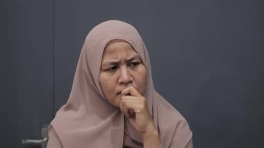 Asyalı Müslüman kadın ciddi düşünce ifadesiyle yukarı bakıyor. Çözülmesi zor sorunlar kavramı.