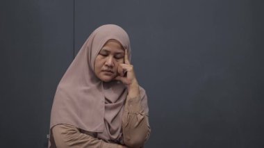 Asyalı Müslüman kadın ciddi düşünce ifadesiyle yukarı bakıyor. Çözülmesi zor sorunlar kavramı.