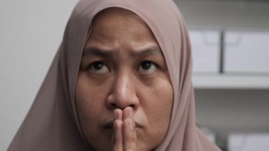 Asyalı Müslüman kadın ciddi düşünce ifadesiyle yukarı bakıyor. Çözülmesi zor sorunlar kavramı.