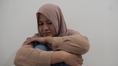 Üzgün Asyalı Müslüman kadın acı ve pişmanlık içinde ağlıyor, kötü haber duyma ya da çatışma kurbanı olma kavramı
