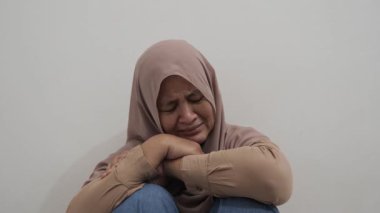 Üzgün Asyalı Müslüman kadın acı ve pişmanlık içinde ağlıyor, kötü haber duyma ya da çatışma kurbanı olma kavramı
