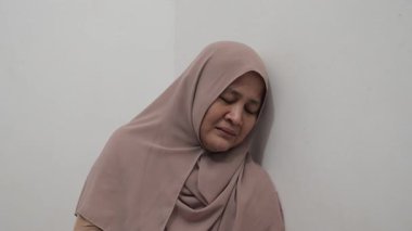 Üzgün Asyalı Müslüman kadın acı ve pişmanlık içinde ağlıyor, kötü haber duyma ya da çatışma kurbanı olma kavramı