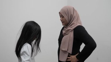 Öfkeli Asyalı Müslüman anne kızını azarlıyor, olumsuz duygu.