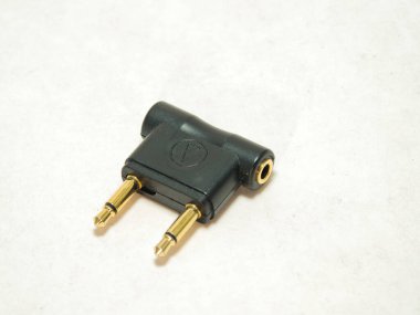 Uçak Kulaklığı Jack Ses Uyarlayıcısı - Siyah, iki uçlu kulaklık takan, beyaz bir arka planda. Seyahat, elektronik ve bağlantı kavramları için temel aksesuar.