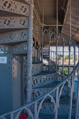 Süslü Demir Sarmal Merdiven Detayı, Lizbon - Santa Justa Asansörü 'nün üst katındaki hassas, Neo-Gotik döşemeli demir sarmal merdivenin yakın çekimi, tarihi metal işçiliğini vurguluyor..