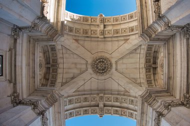 Rua Augusta Arch Kasa Tavanı Mimarisi - Lizbon 'daki Rua Augusta Kemeri' nin içindeki süslemeli tavan manzarası, neoklasik oymalar ve parlak mavi gökyüzü açılışı.