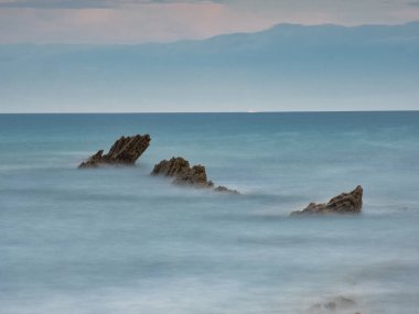 Sinek Kayası Öncü Hattı Mavi Saat Kıyısı - Serin mavi bir saatin altında dağlara doğru lider bir çizgi görevi gören tek bir kaya oluşumunun dramatik uzun pozu.