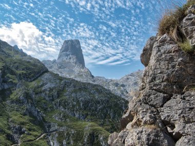 Picos de Europa Ulusal Parkı 'ndaki Picu Urriellu Yürüyüş Patikası - İspanya' nın Asturias kentindeki zorlu patikadan Altocumulus bulutlarıyla dolu güneşli bir günde Naranjo de Bulnes 'in dramatik manzarası.