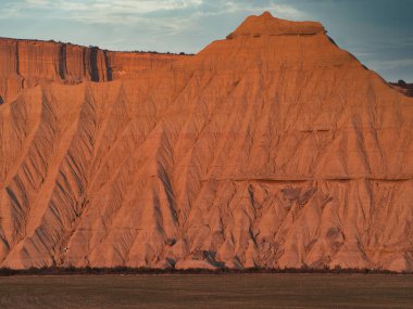 Golden Hour 'daki soyut Çöl Çorak Toprakları Dokusu- Sert bir kenar altında aşınmış kil ve kumtaşı tepelerinin ve çorak toprakların tepelerinin çarpışması güçlü çapraz gölgeler oluşturur..