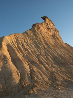 Golden Hour 'daki soyut Çöl Çorak Toprakları Dokusu- Sert bir kenar altında aşınmış kil ve kumtaşı tepelerinin ve çorak toprakların tepelerinin çarpışması güçlü çapraz gölgeler oluşturur..
