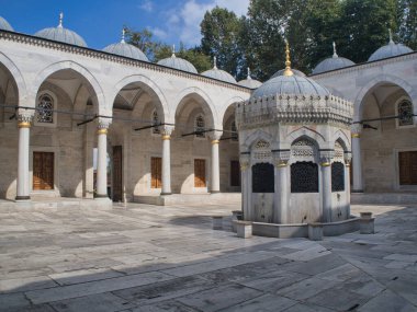 Osmanlı Mezarlığı Tombstone ve Trbe Tarihi Osmanlı mezar taşları, el yazısı ve oymalarla dolu, kubbeli bir mozole (trbe) tarafından çerçevelenmiş, huzurlu bir mezarlıkta yeşillikler arasında duruyor.).