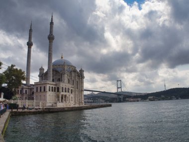 Osmanlı Mezarlığı Tombstone ve Trbe Tarihi Osmanlı mezar taşları, el yazısı ve oymalarla dolu, kubbeli bir mozole (trbe) tarafından çerçevelenmiş, huzurlu bir mezarlıkta yeşillikler arasında duruyor.).