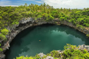 Turtles Hole in the north of Ouvea Island, Loyalty Islands, New Caledonia. This hole is connected undeground to the sea. clipart