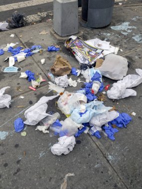 Bronx, New York - 17 Ağustos 2023: Temizlik malzemesi çöp poşeti alındıktan sonra kaldırıma bırakılan maske ve eldivenli çöpler. 