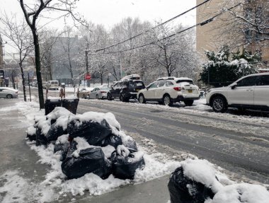 Bronx, New York - 13 Şubat 2024: Çöp torbaları kar düştükten sonra temizleme kamyonlarının toplanmasını bekliyor.