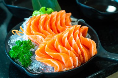 Sashimi, Somon, Japon yemek çubukları ve siyah masada wasabi. 