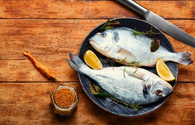 Tabakta yemek pişirmek için iki çiğ dorado balığı, diyet. Pişmemiş balık. Boşluğu kopyala