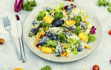 Domatesli salata, biber, otlar ve midye. Sağlıklı salata tabağı