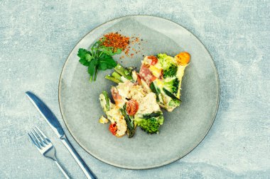 Pastırmaya sarılmış kuşkonmaz, domates, brokoli ve peynirle pişirilmiş. Keto diyeti, düz yatak.