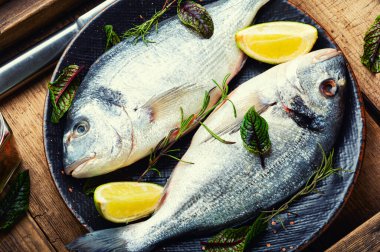 Tabakta pişirmek için iki çiğ dorado balığı. Pişmemiş balık