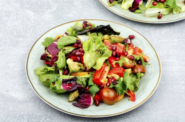 Yeşillik, biber, kırmızı marul ve salatalıklı vitamin salatası, nar ile süslenmiş..