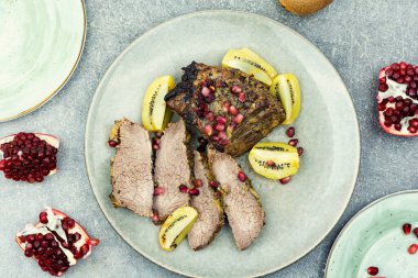 Prepared beef meat in kiwi and pomegranate sauce. Top view