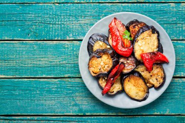 Roasted eggplant and grilled bell pepper on a plate. Top view with copy space