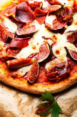 Homemade meat pizza with cheese and figs.