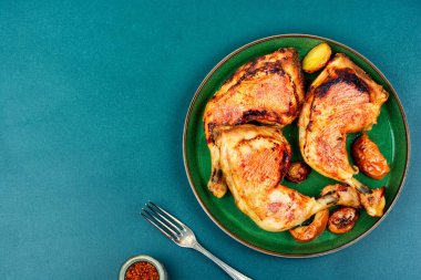 Roasted chicken leg on the plate. Grilled meat. Copy space.