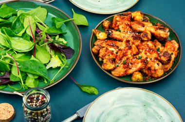 Baked chicken wings with vegetables. BBQ and salad lettuce