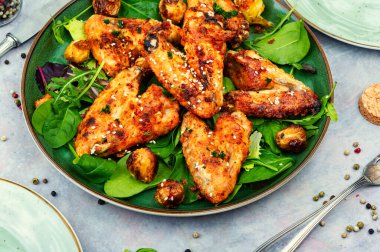 Roasted chicken wings with vegetables. Traditional baked barbecue