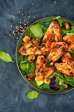 Appetizing spicy chicken wings with vegetables. Top view