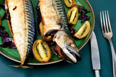 Tasty mackerel fish grilled with kiwi on a kitchen table