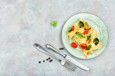 Vegetable gratin with broccoli and tomatoes on a plate. Casserole foods, space for text