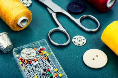 Home sewing kit, scissors, pin, colorful thread and buttons. Needlework concept
