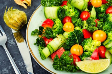 Fresh salad with broccoli, tomato, cucumber and physalis. Vegetarian food