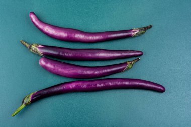 Raw small eggplants on the kitchen table.