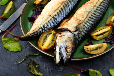 Two mackerel fish roasted with kiwi pieces.