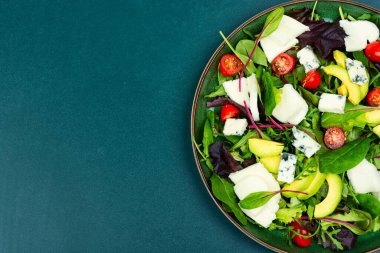 Salad with fresh lettuce, greens, avocado, tomatoes and cheeses. Space for text