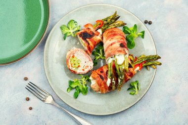 Et ile sarılmış kızarmış yeşil kuşkonmaz. Üst görünüm