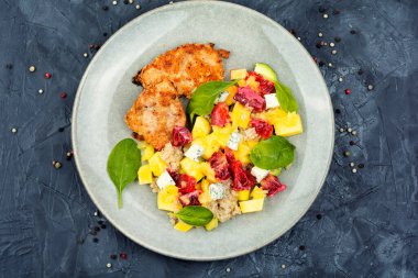 Fresh salad with chicken meat, orange, pineapple and quinoa.