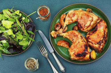 Kızarmış tavuk budu ve taze yeşil salata.