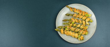 Hamur içinde pesto sosuyla pişirilmiş yeşil kuşkonmaz. Uzayı kopyala Pankart.