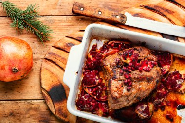 Eski ahşap masada nar ile pişirilmiş güzel kokulu jambon. Noel için et tarifi. Kırsal tarzda..