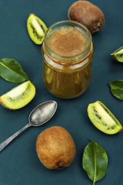 Jam or marmalade made from kiwi in a glass jar. Delicious kiwi jam on table