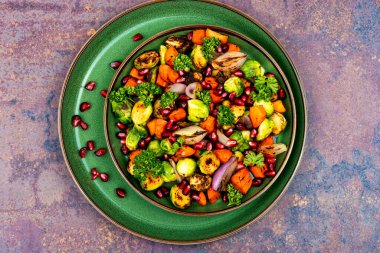 Delicious vegetable salad of boiled brussels sprouts, herbs and physalis. Vegan salad. Top view clipart